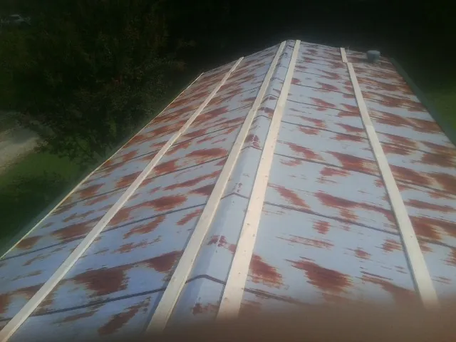 Rusted metal roof panels with new wood purlins before replacement — Storm Damage Roof Repair in Faxon by Roofing Brothers