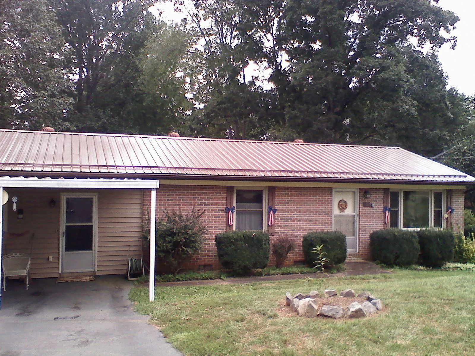 Bronze metal roof and carport on a brick ranch home — Roof Repair work by our crew in Faxon