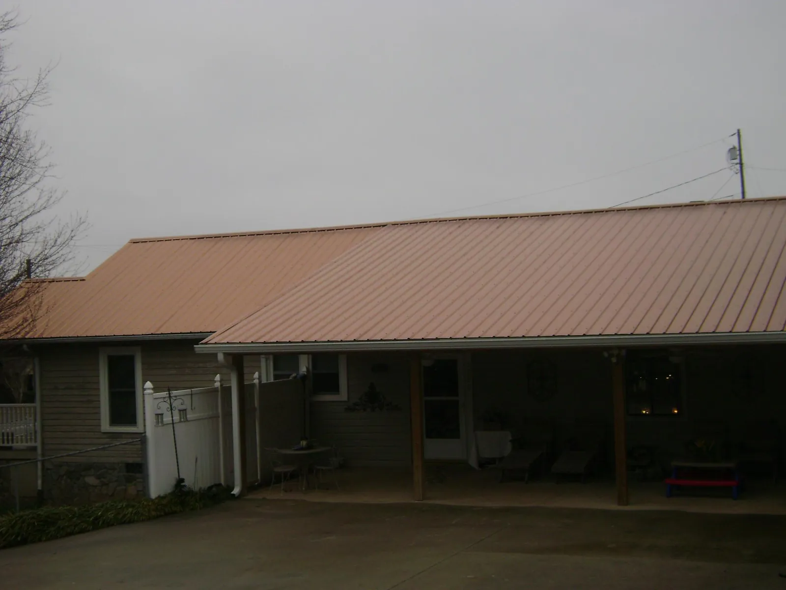 Copper toned metal roof over a wide covered patio in Faxon